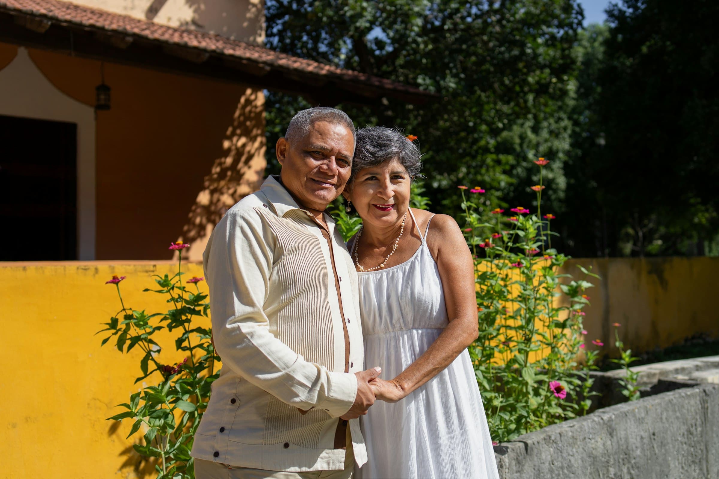 Pareja mayor sonriendo en el jardín
